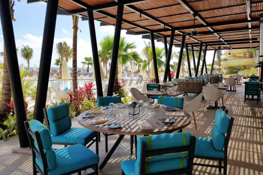 Grill and steakhouse restaurant terrace with views of the pools and beach of a weddings resort in cancun