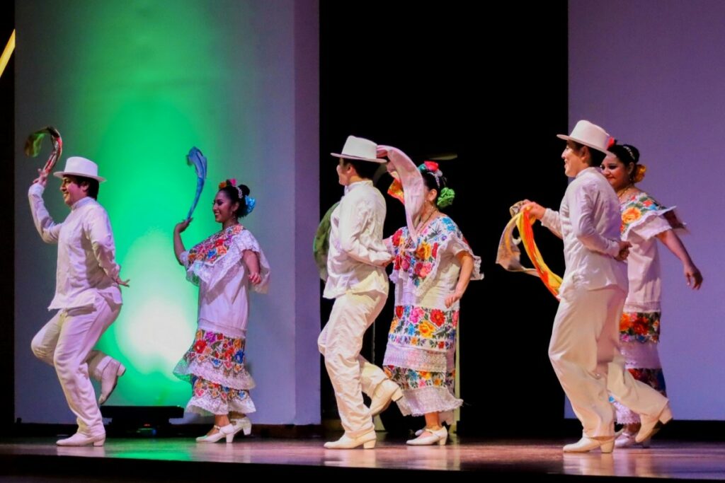 Traditional mexican dancers wearing white attires with colorful scarfs