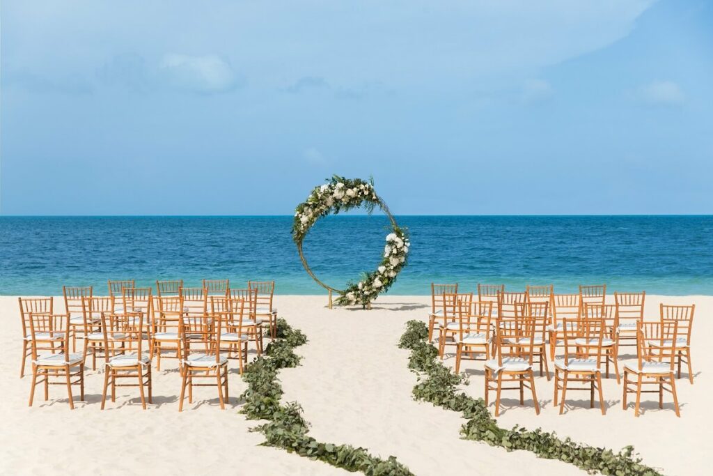 cérémonie sur la plage avec chaises tiffany dorées mariages Excellence Playa Mujeres