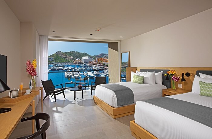 room with two double beds and a view of the marina