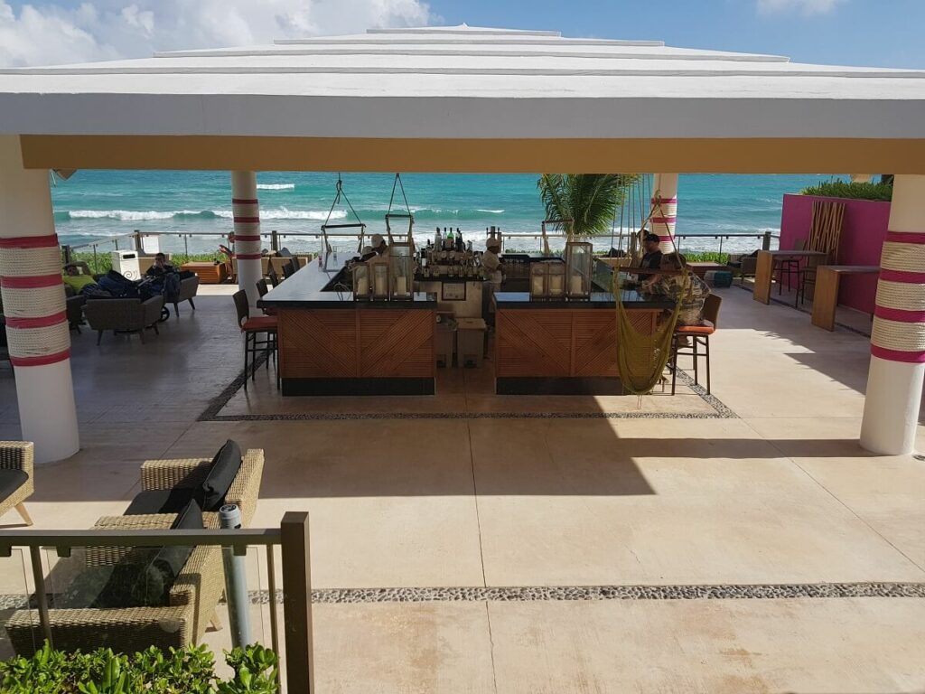 outdoor bar area with swings and ocean views at now jade