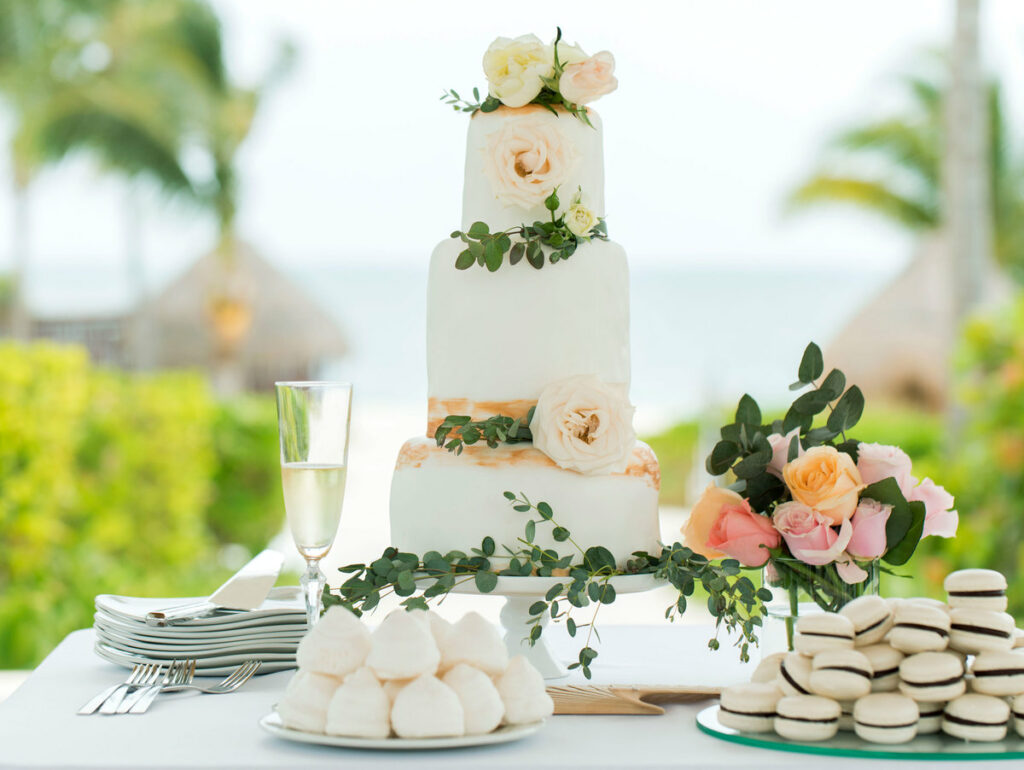 Three tiered wedding cake with pink flowers and, macaroons and cookies