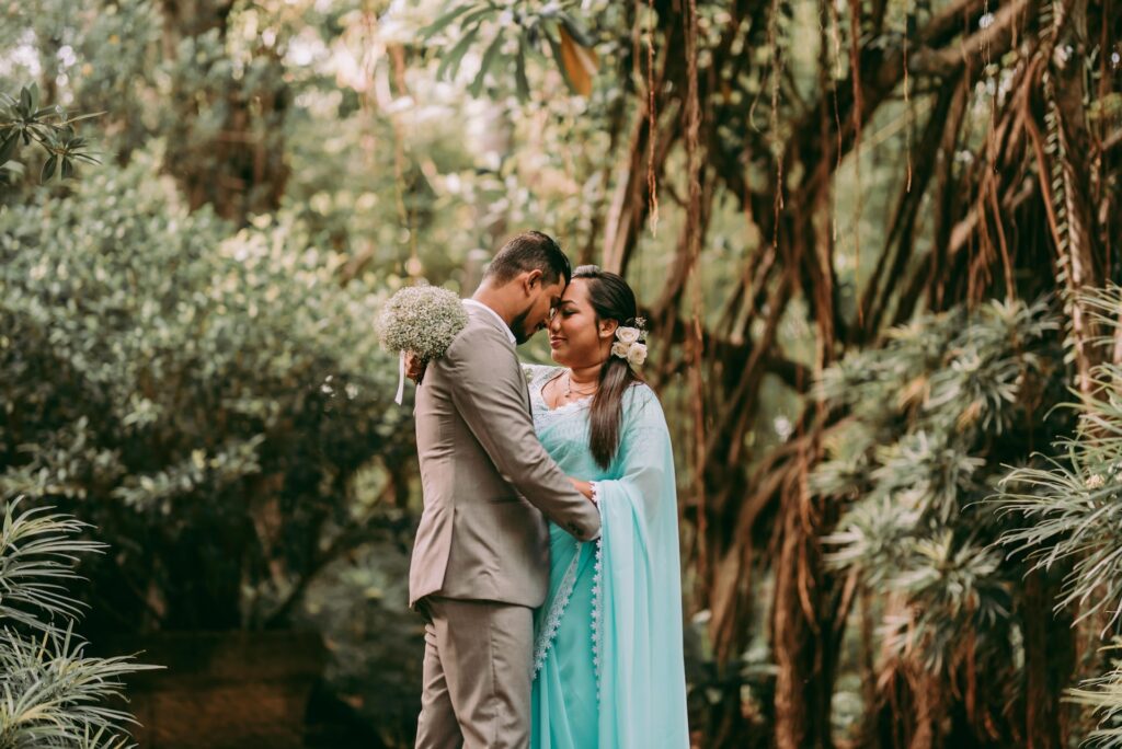 A multi cultural couple getting married in a lush tropical garden