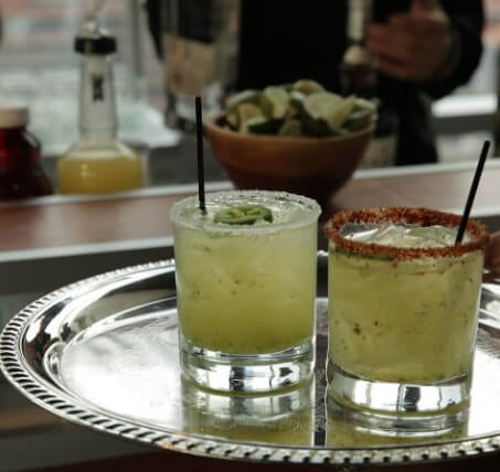 two cocktails with lime and chile