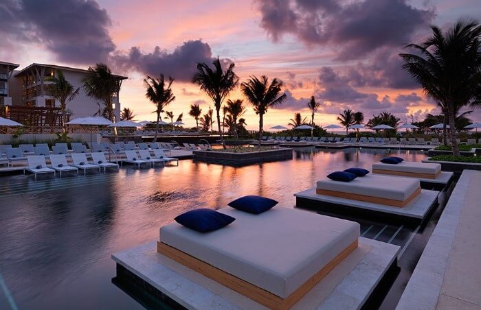 unico hotel swimming pool with double bed loungers at dusk