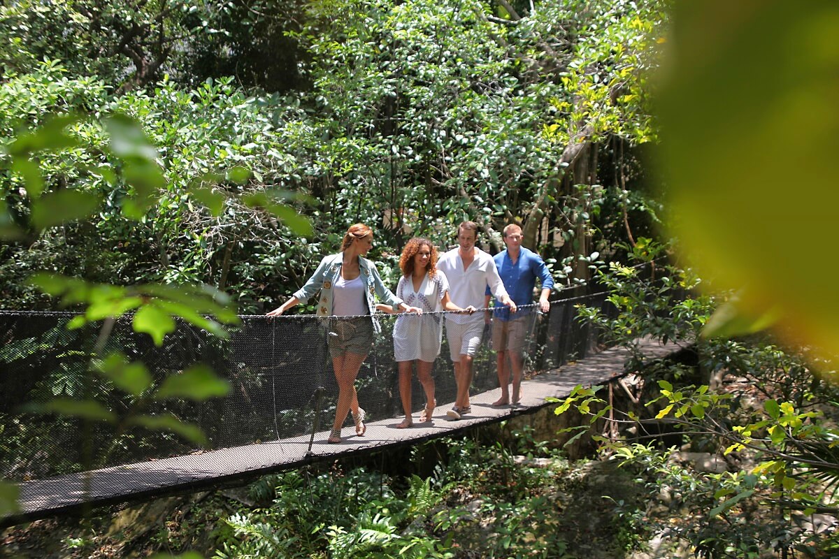 Guests crossing a wooden bridge in the gardens