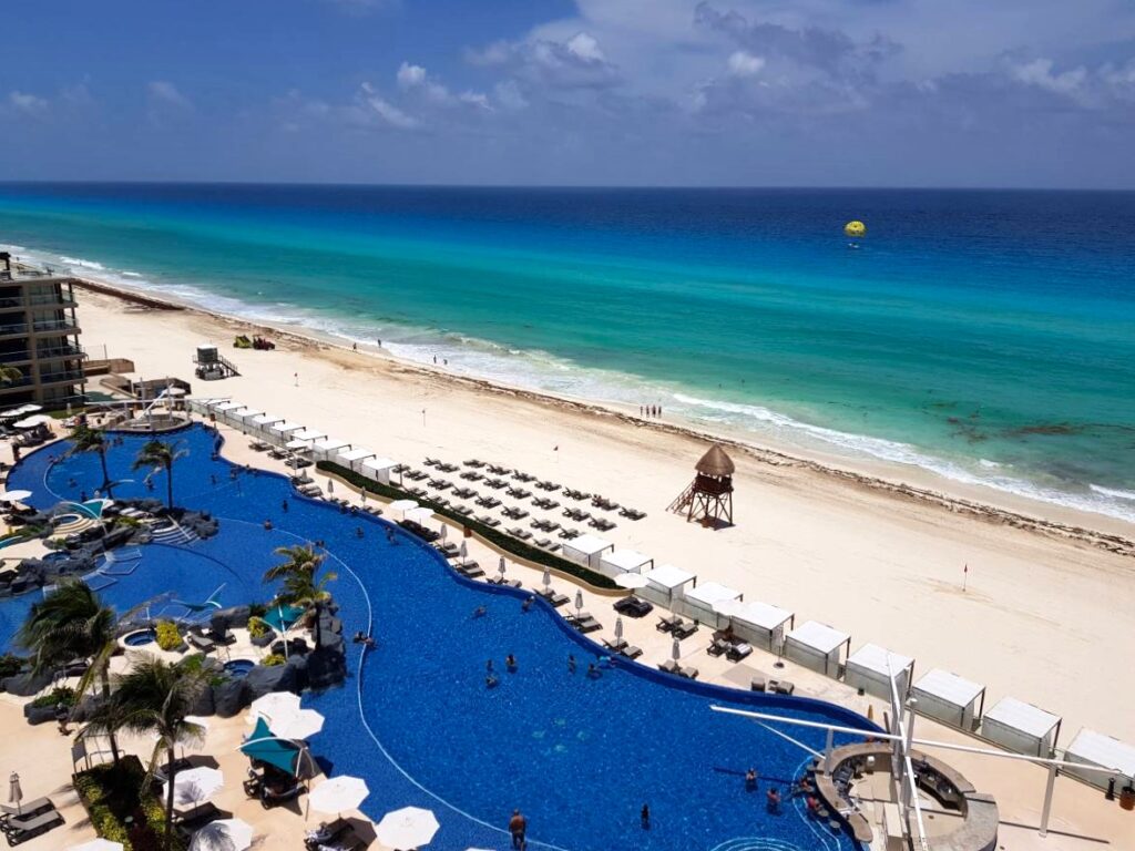 Aerial view of the expansive clear beach and pool of Hard Rock Hotel in Cancun