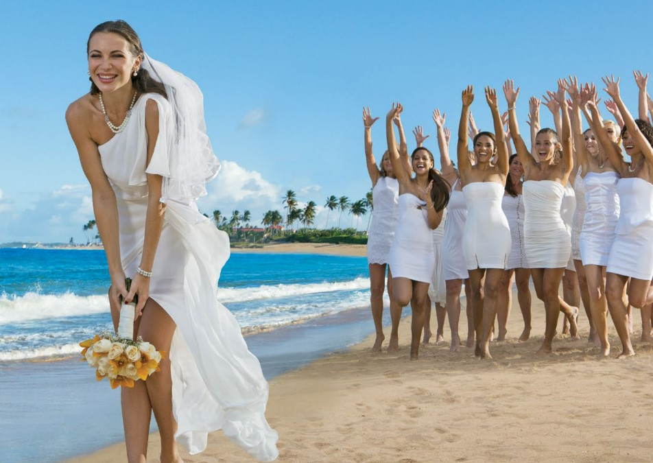 Bride tossing the flower bouquet to the bridesmaids at the beach