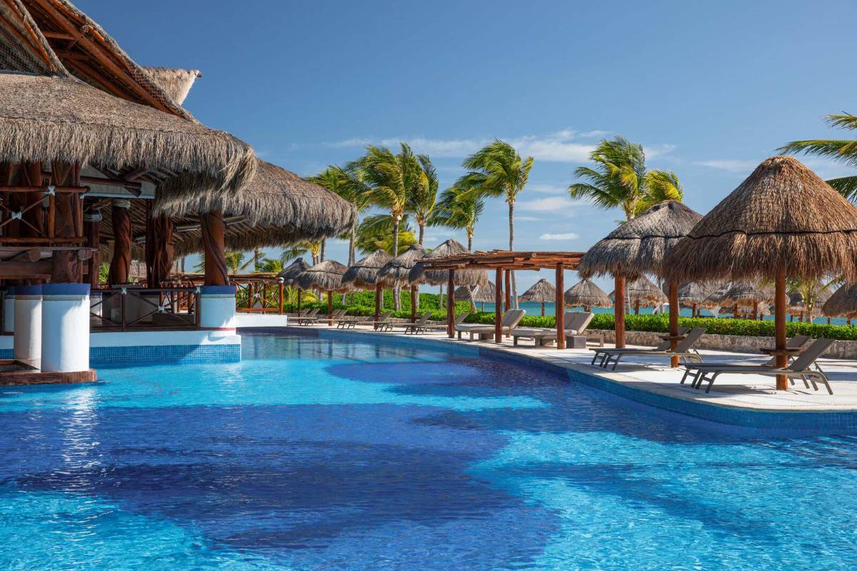 Ocean front pool with palapa hut bar and lounge chairs