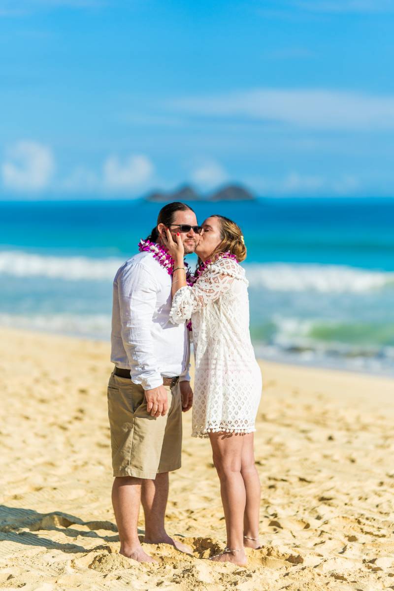 Bride kissing the groom after their wedding ceremony on the beach