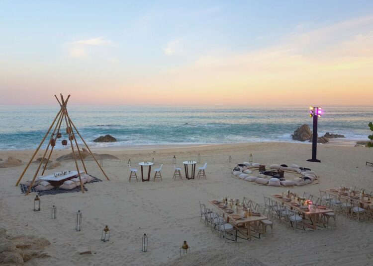 Pirvate beach event at sunset with a tipi and fire pit