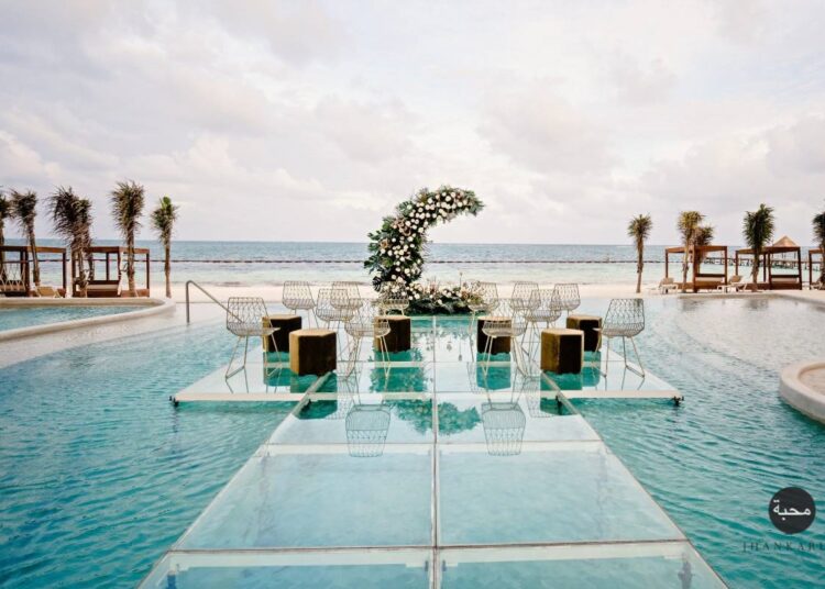 Over the water wedding setting on a pool with a half moon flower arrangement