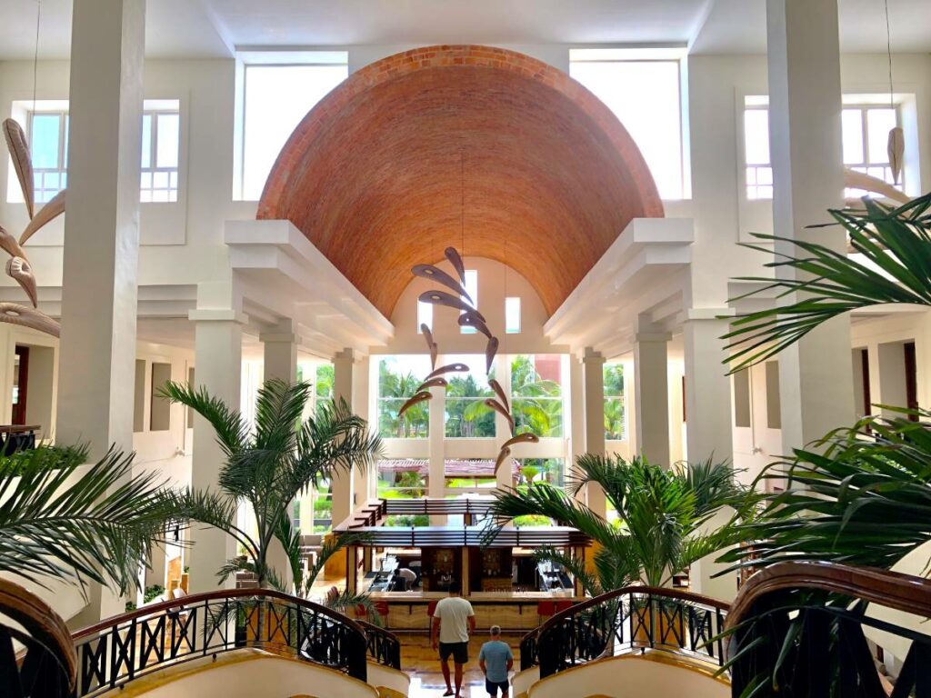 Lobby bar and grand staircase with large palmtrees and big windows