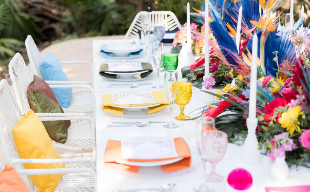 Colorful wedding table with bright color accents, flowers and cushions