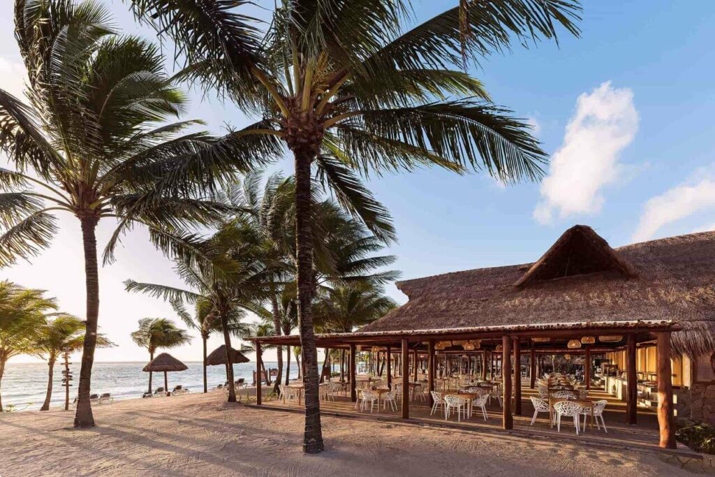 Hotel beach restaurant with palapa roof and palmtrees