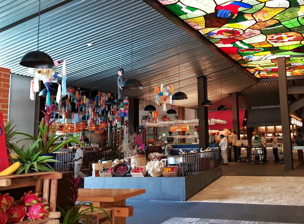 Mexican restaurant with traditional decoration with pinatas, basquets and colorful stained glass ceiling