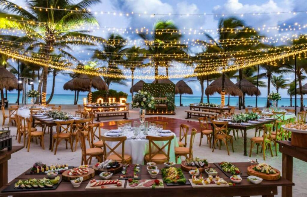 Oceanfront beach venue with bistro lights and a wedding set up