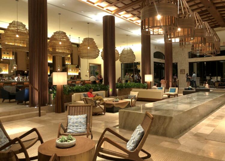 Elegant resort lobby bar with marble floors, wooden furniture and a fountain