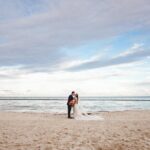 destination wedding planning steps with a couple kissing at the beach