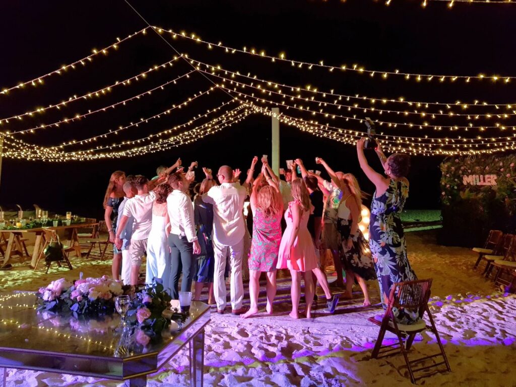 Wedding reception on the beach with wedding guests toasting