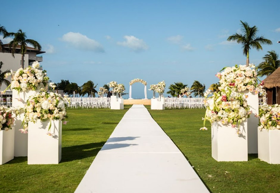 Huge garden set up for a weddign ceremony with flower arrangements and a wedding arch