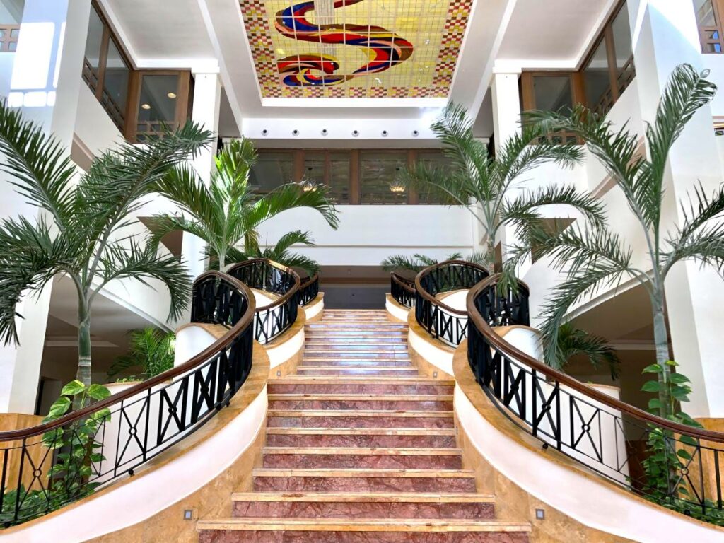 Grand hotel staircase with palmtrees and stainglass in the ceiling