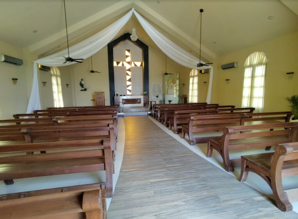 Catholic wedding chapel with wooden benches and white drapes