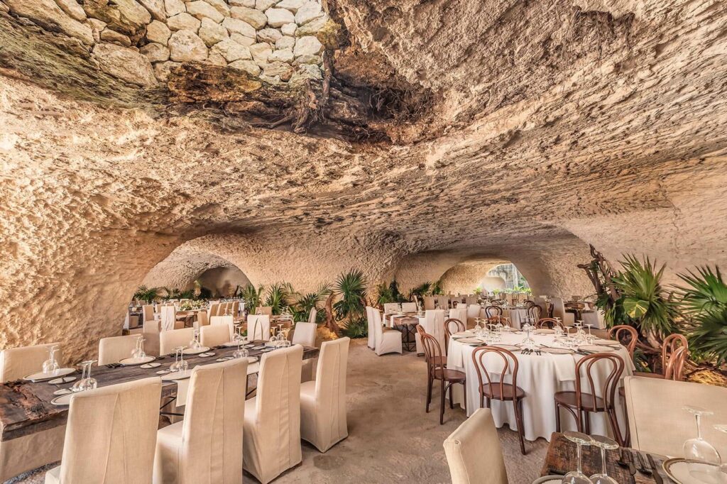 Impressive wedding venue under a cave set up with wooden tables and chairs
