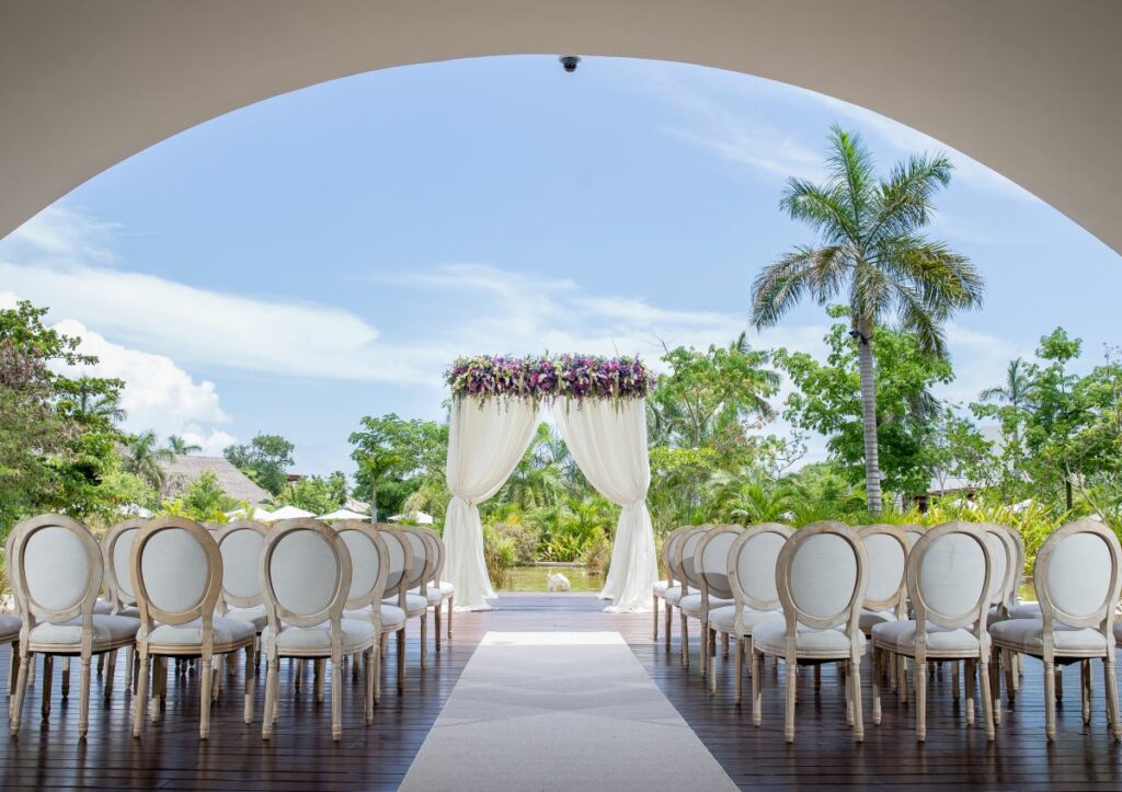 Wedding gazebo set up at the lagoon arch of secrets akumal with elegant chairs and purple flowers