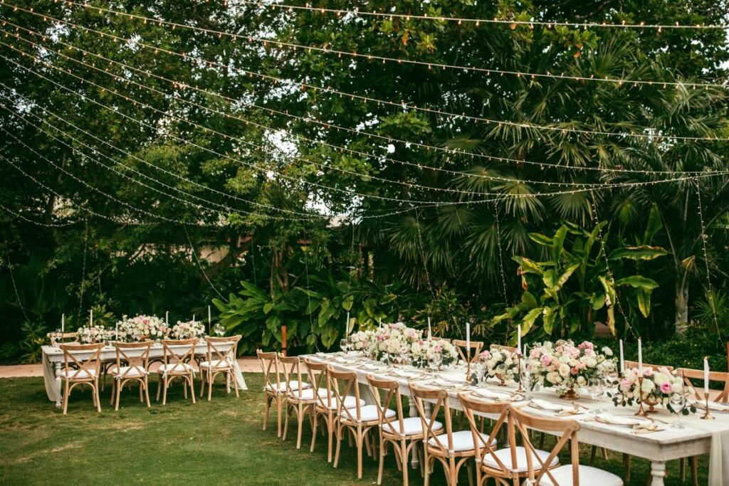 Wedding set up in a secret garden with large tables and pink flowers