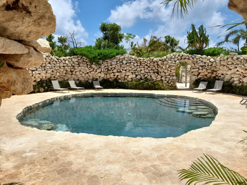 Pool in a form of a cenote with a stone wall around it