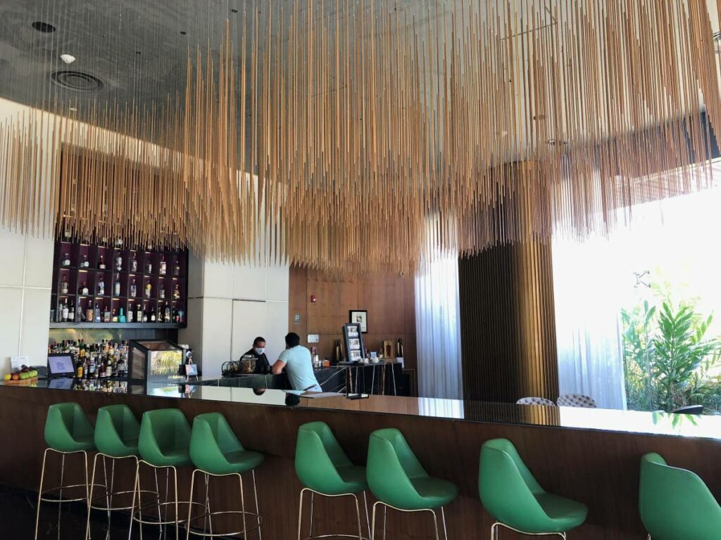 Lobby bar with green chairs and hanging art
