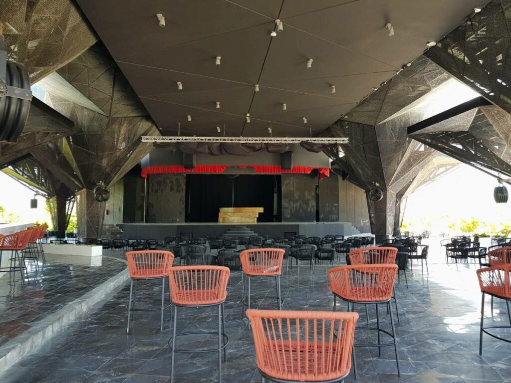 Big open theatre with a steel structure and black and orange chairs