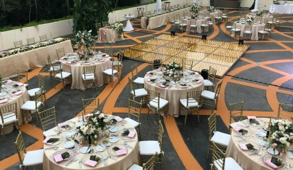 Wedding set up with round tables with gold chairs and led dance floor