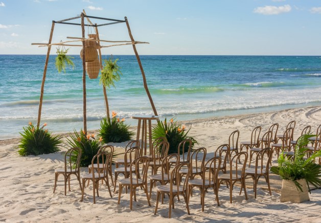 Wedding pergola at the beach with tropical leaves and flowers
