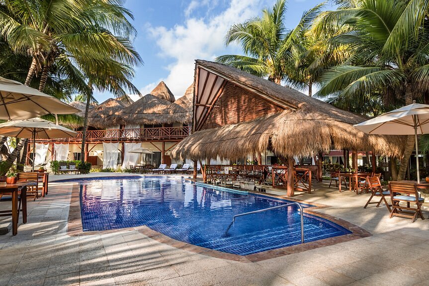 Resort pool with swim up bar with palapa roof