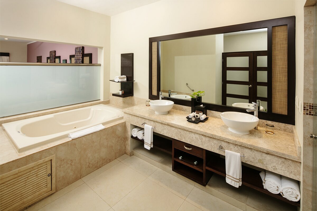 Hotel bathroom with bathtub and two double vanities with a big mirror