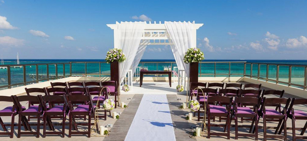 Rooftop with a wedding gazebo with white drapes and ocean view