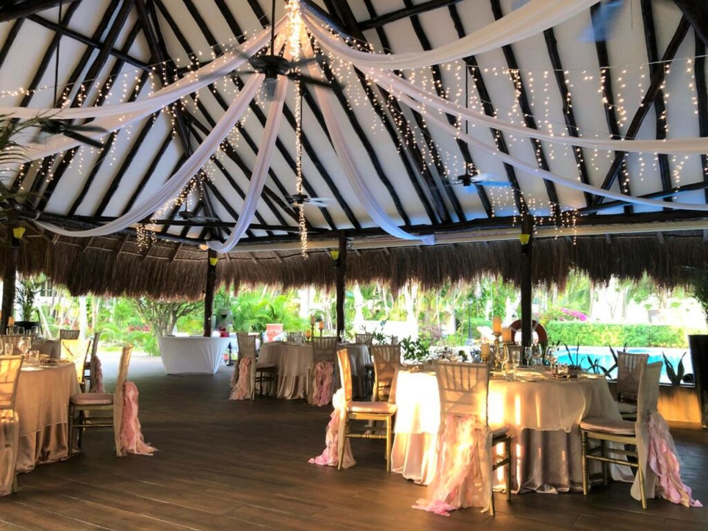 Tables with wedding decorations and white fabrics as ceiling decoration