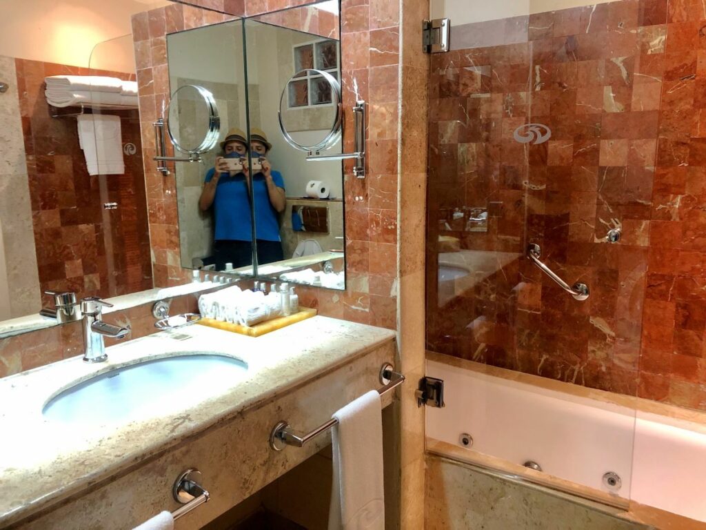 Hotel bathroom with a bathtub a large mirror and bath toiletries