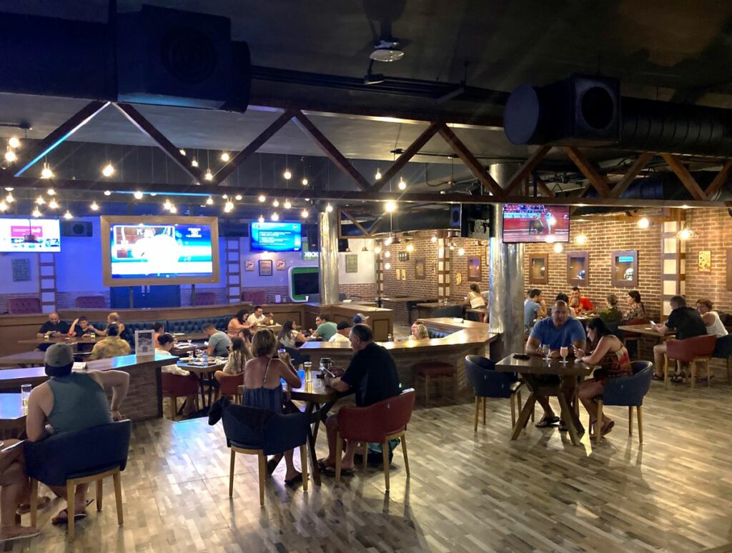Indoor sportsbar with big screens and people watching a game