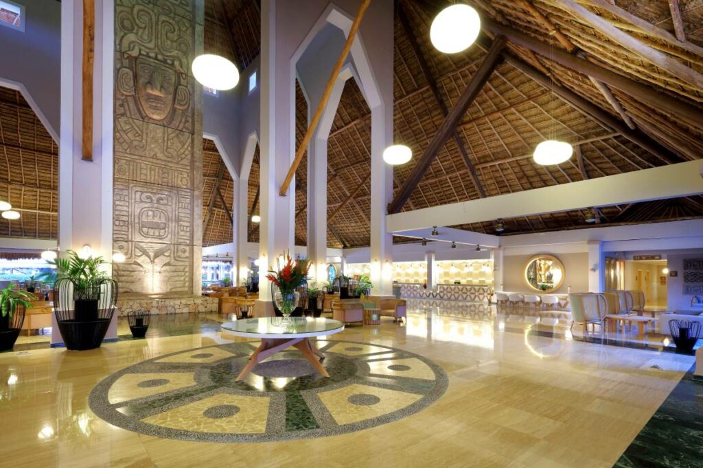 Hotel lobby with a big palapa roof and indigenous sculptures