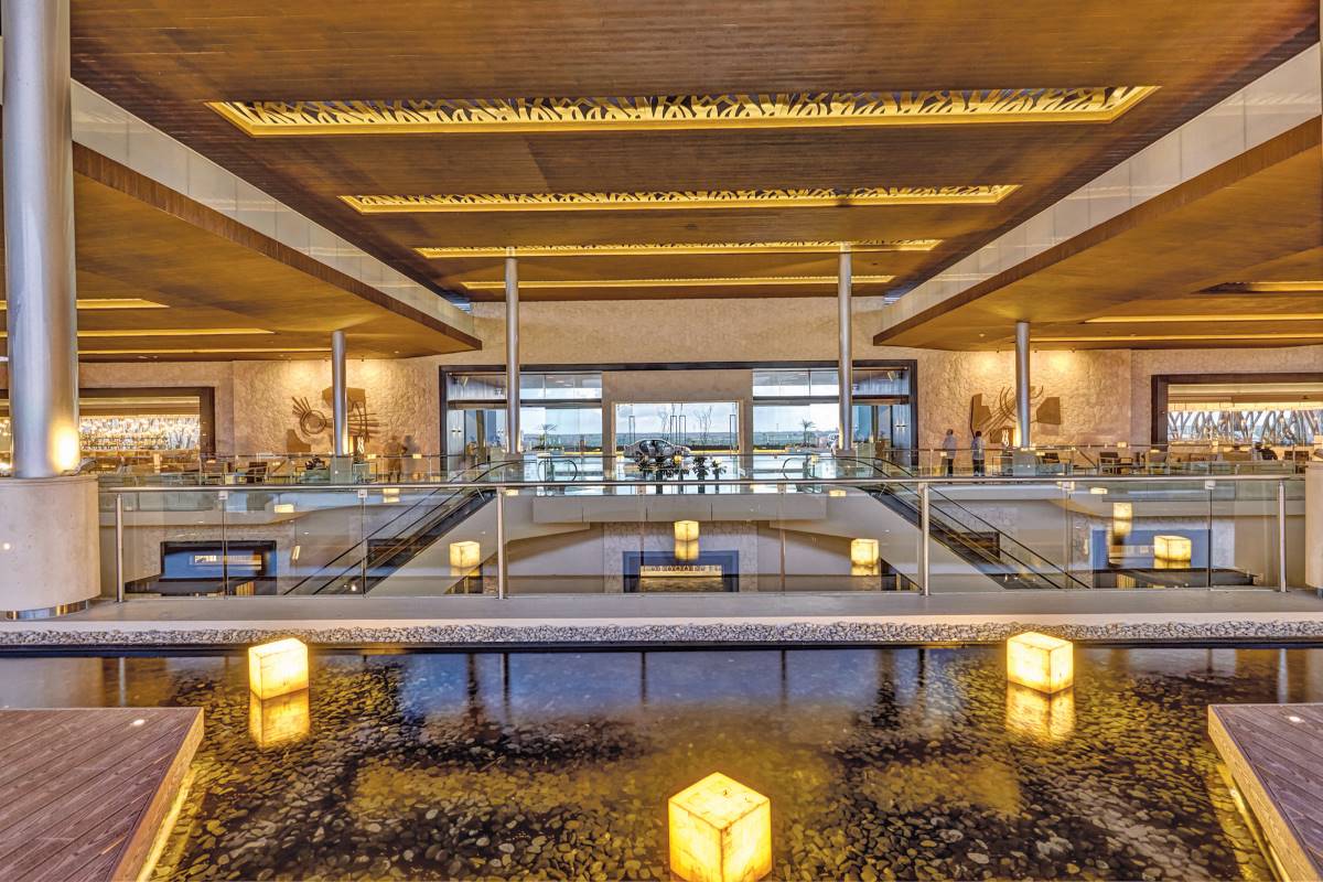 modern resort lobby with water mirrors, floating lamps and high ceilings