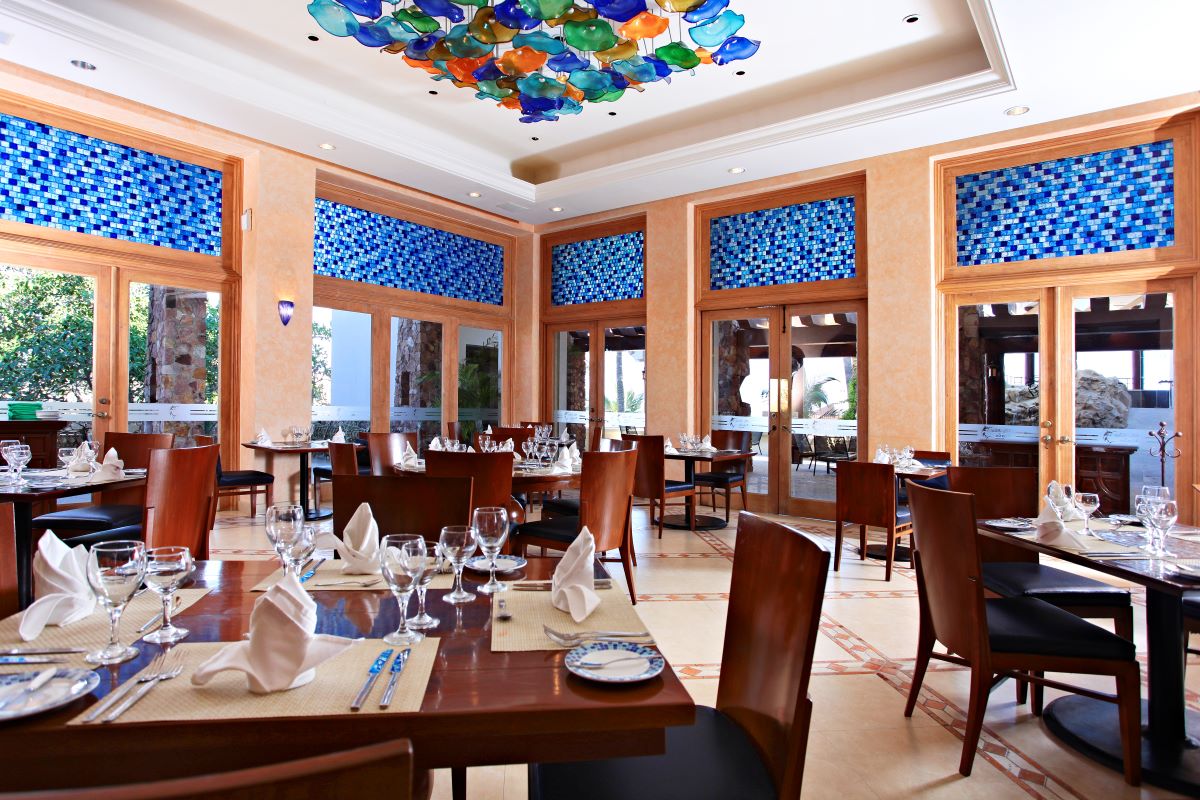 Hotel restaurant with wooden furniture, blue mosaics and colored glass lights