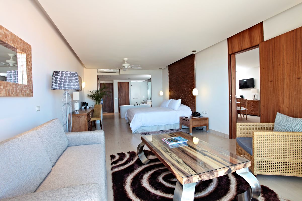 Hotel suite with wooden furniture, neutral colors and a living area