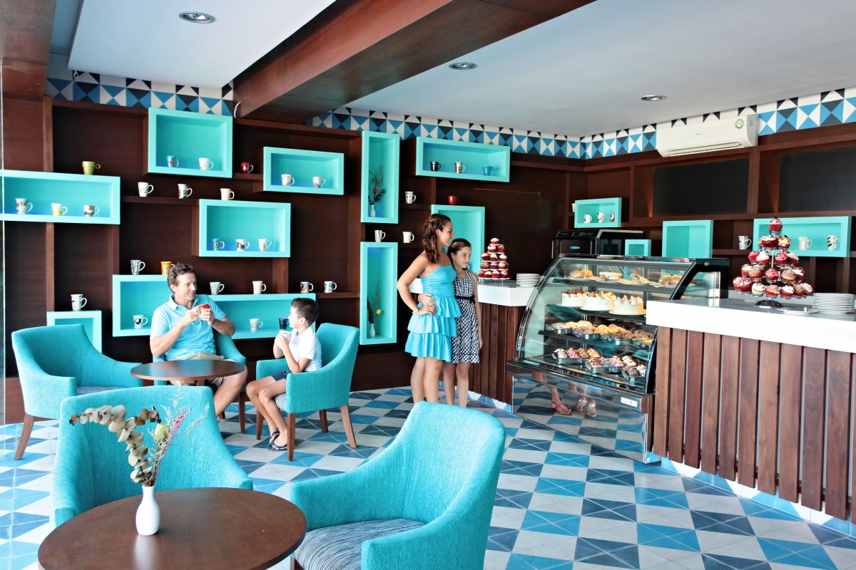 coffee shop decorated in blue and brown with lots of pastries and cupcakes