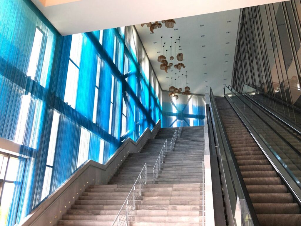Convention center grand staircase with hanging lanterns and blue drapes