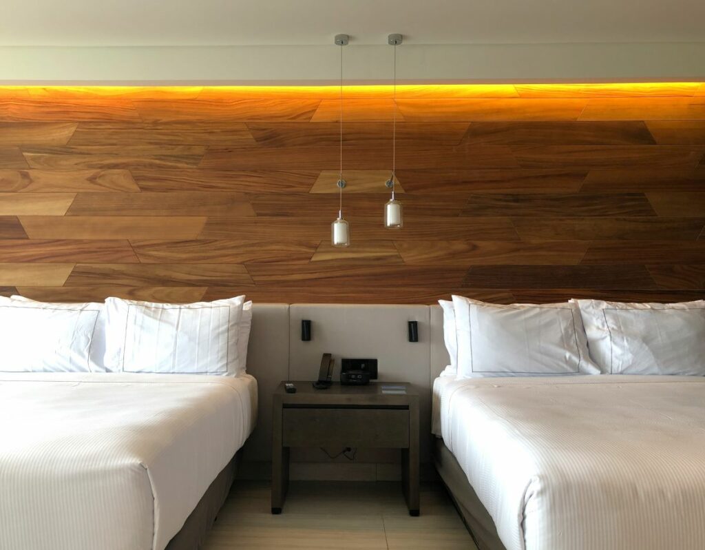 Double bed hotel room with hanging lanterns and wood wall