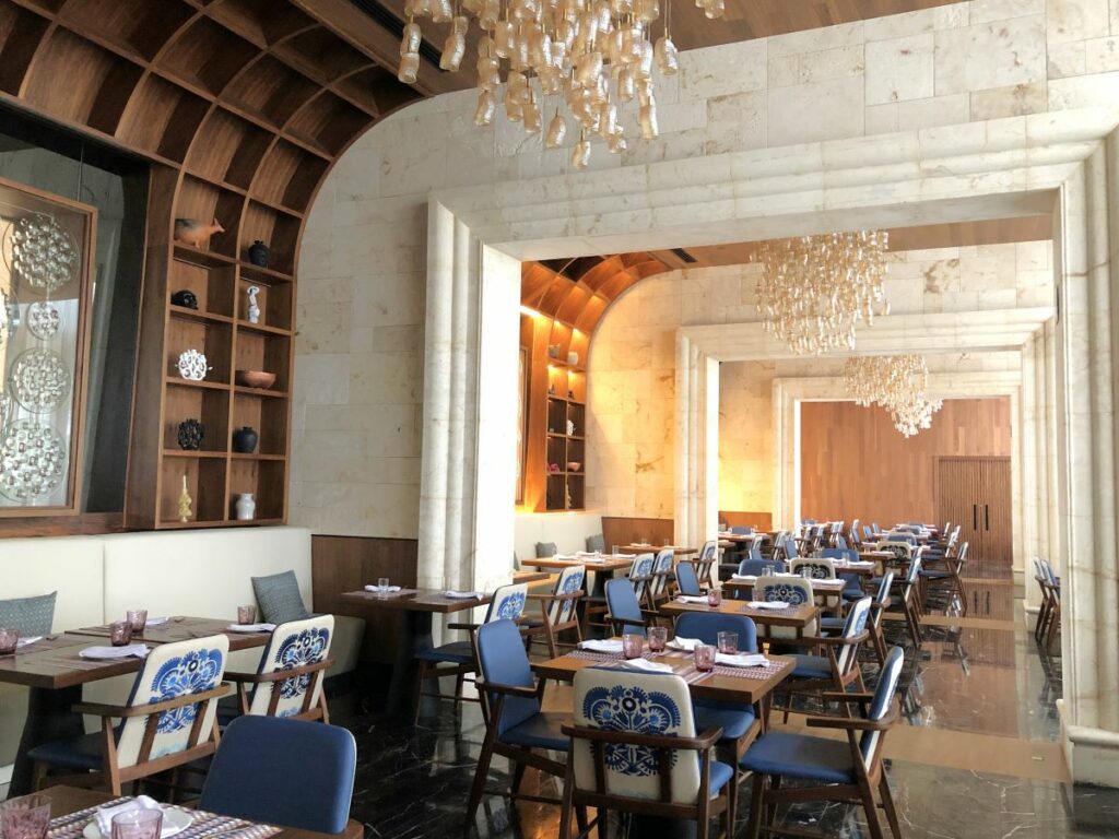 Elegant restaurant with chandeliers, wooden walls and blue chairs