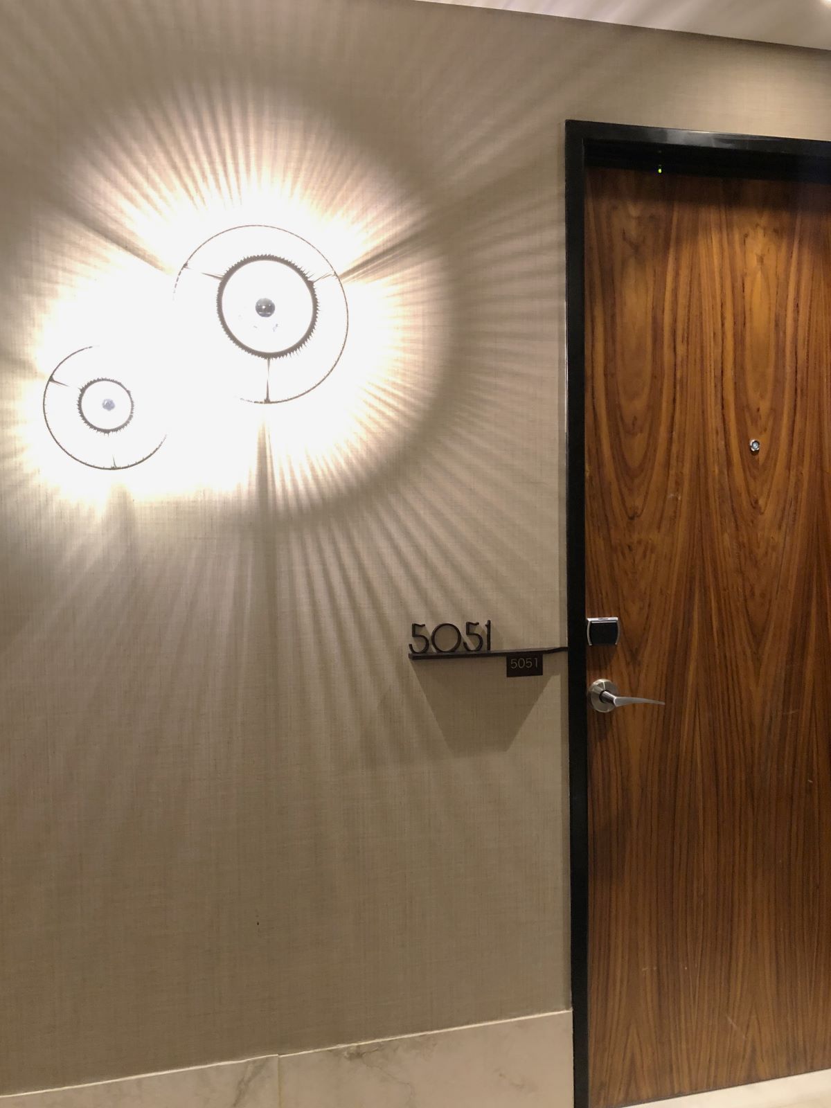Outdoor of a hotel room with light fixtures and wooden door